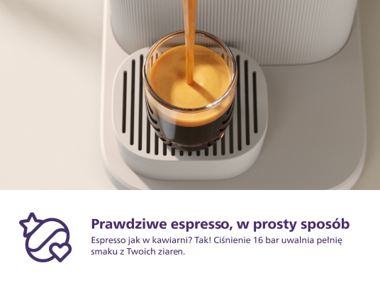 Espresso wlewa się do szklanki, z białego ekspresu.