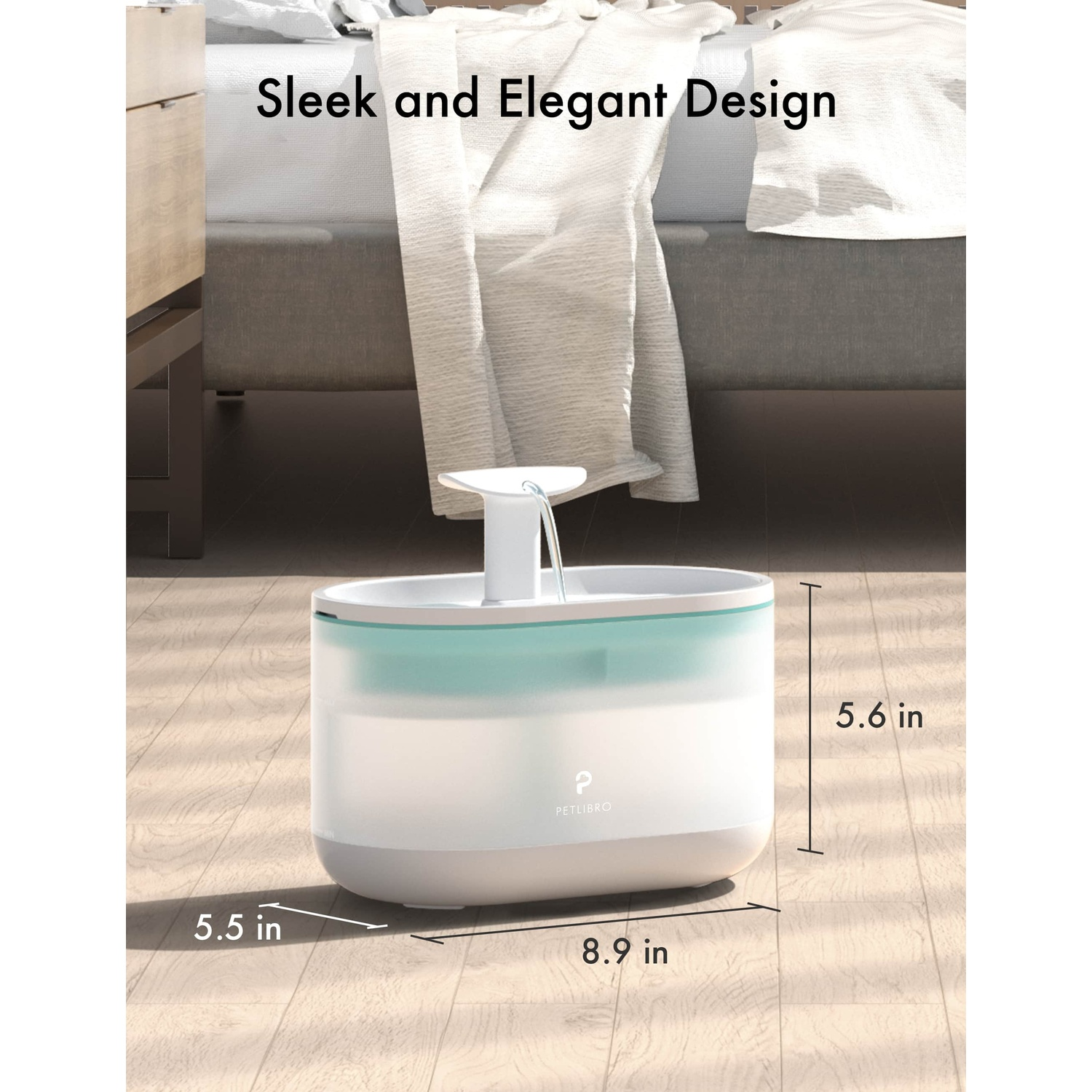 A pet water fountain, white and blue. Dimensions are displayed. Background: wood floor and a bed.