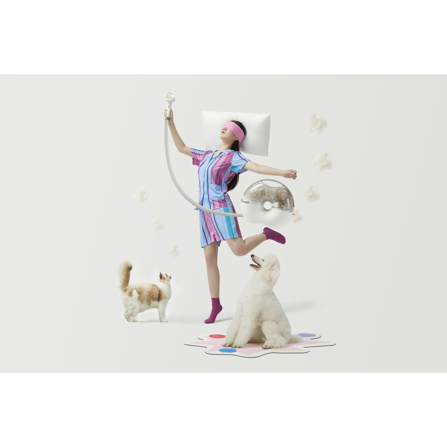 Woman with eye mask, cat, dog, and grooming equipment on white.