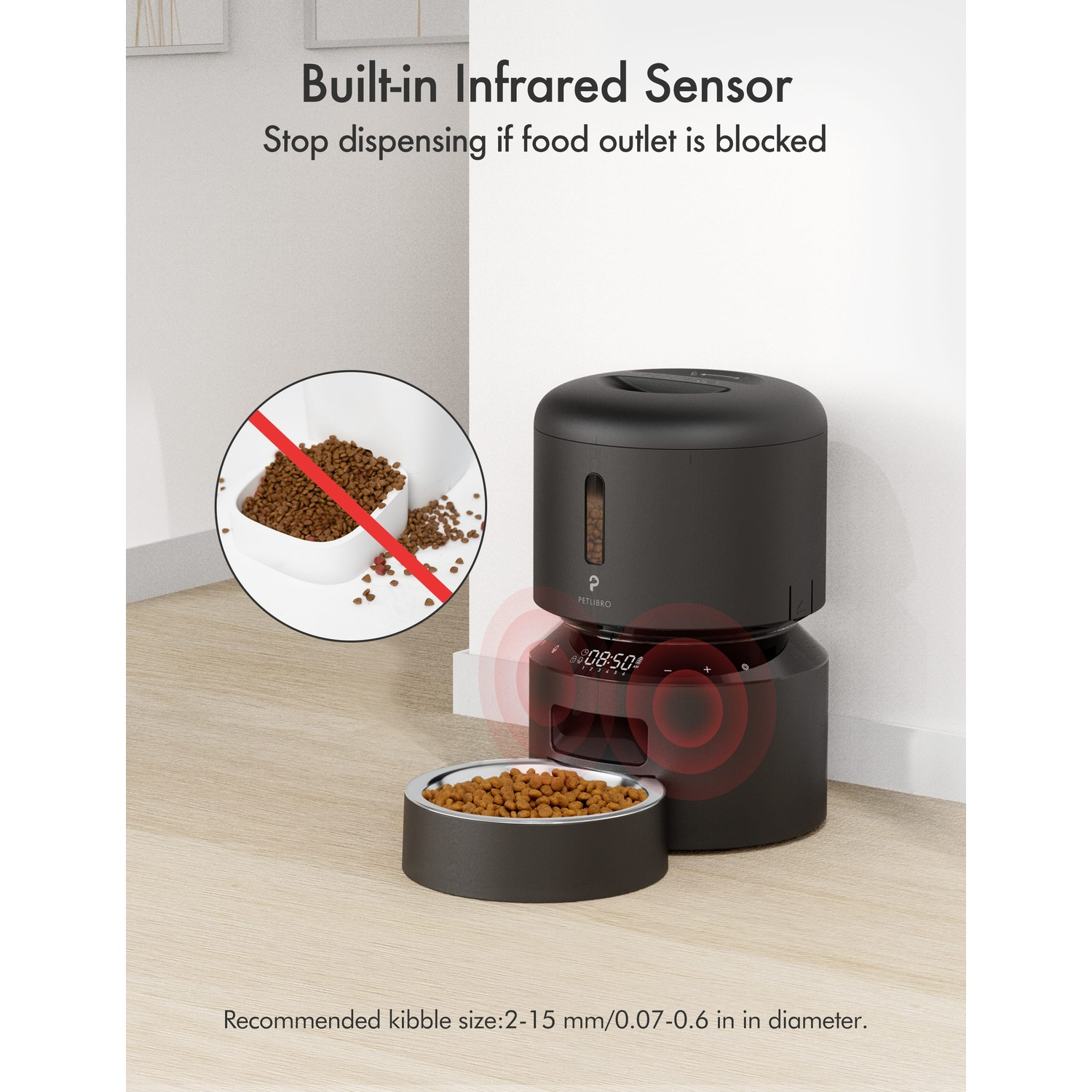 Black pet food dispenser. Bowl filled with food, and a timer. White wall background.