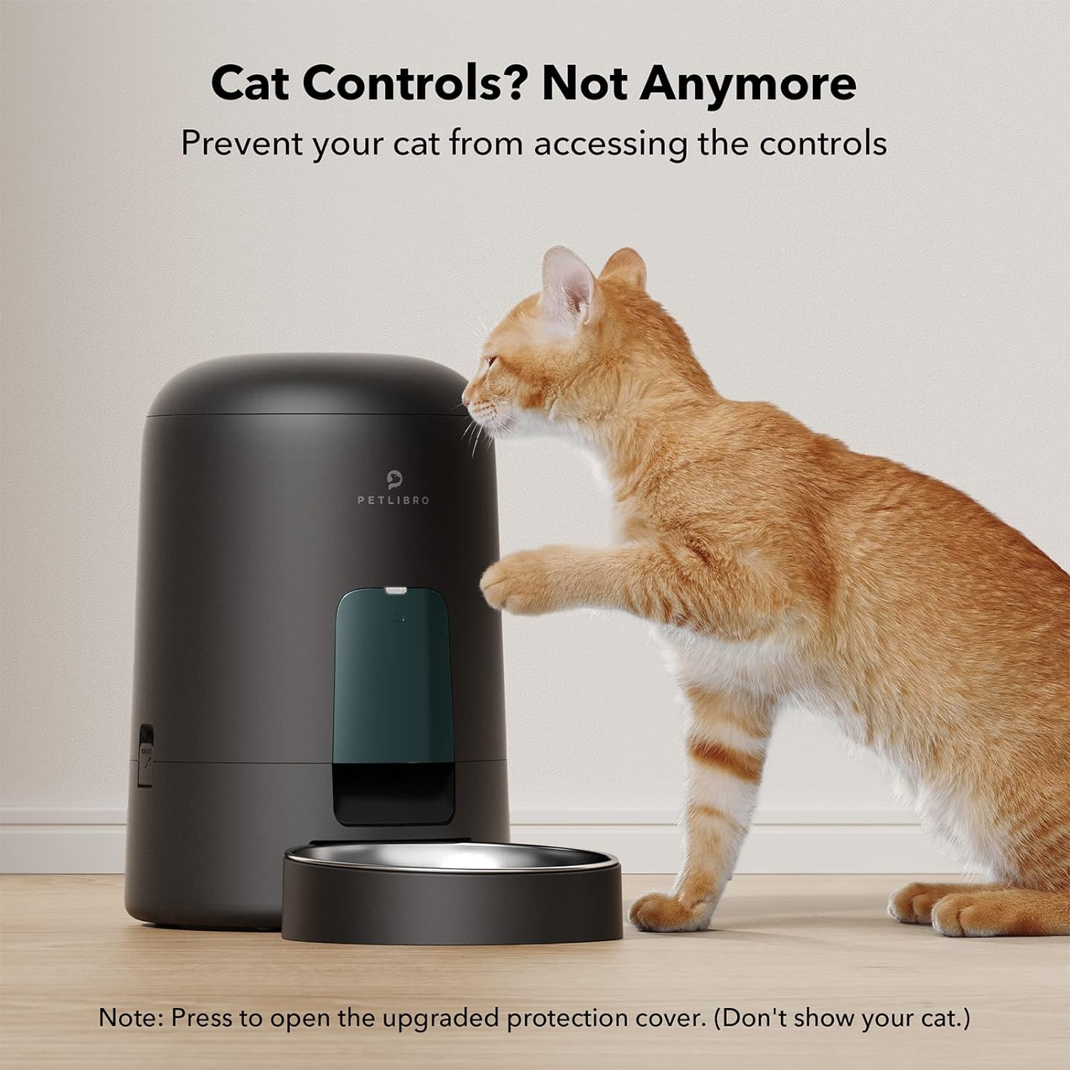 A cat interacting with a black pet food dispenser.