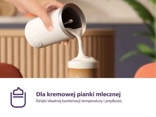 Dłoń wlewa pianę mleczną do szklanki kawy. Tekst: Dla kremowej piany mlecznej.