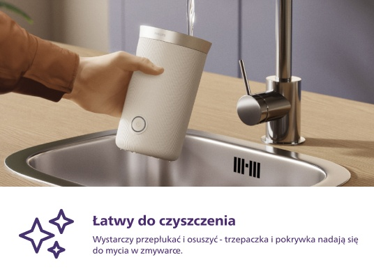 Ręka osoby trzymająca biały pojemnik nad zlewem.