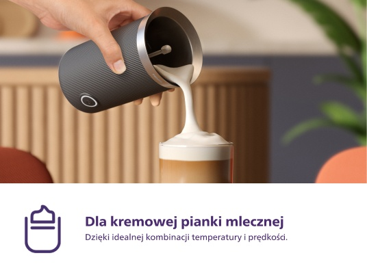 Spieniacz do mleka wlewa mleko do kawy, biała pianka.