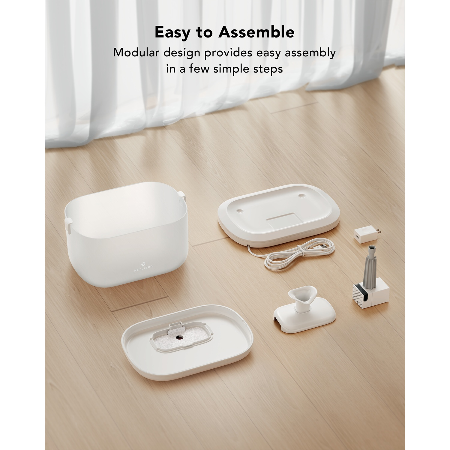 White pet fountain parts, disassembled, with a wood floor background.