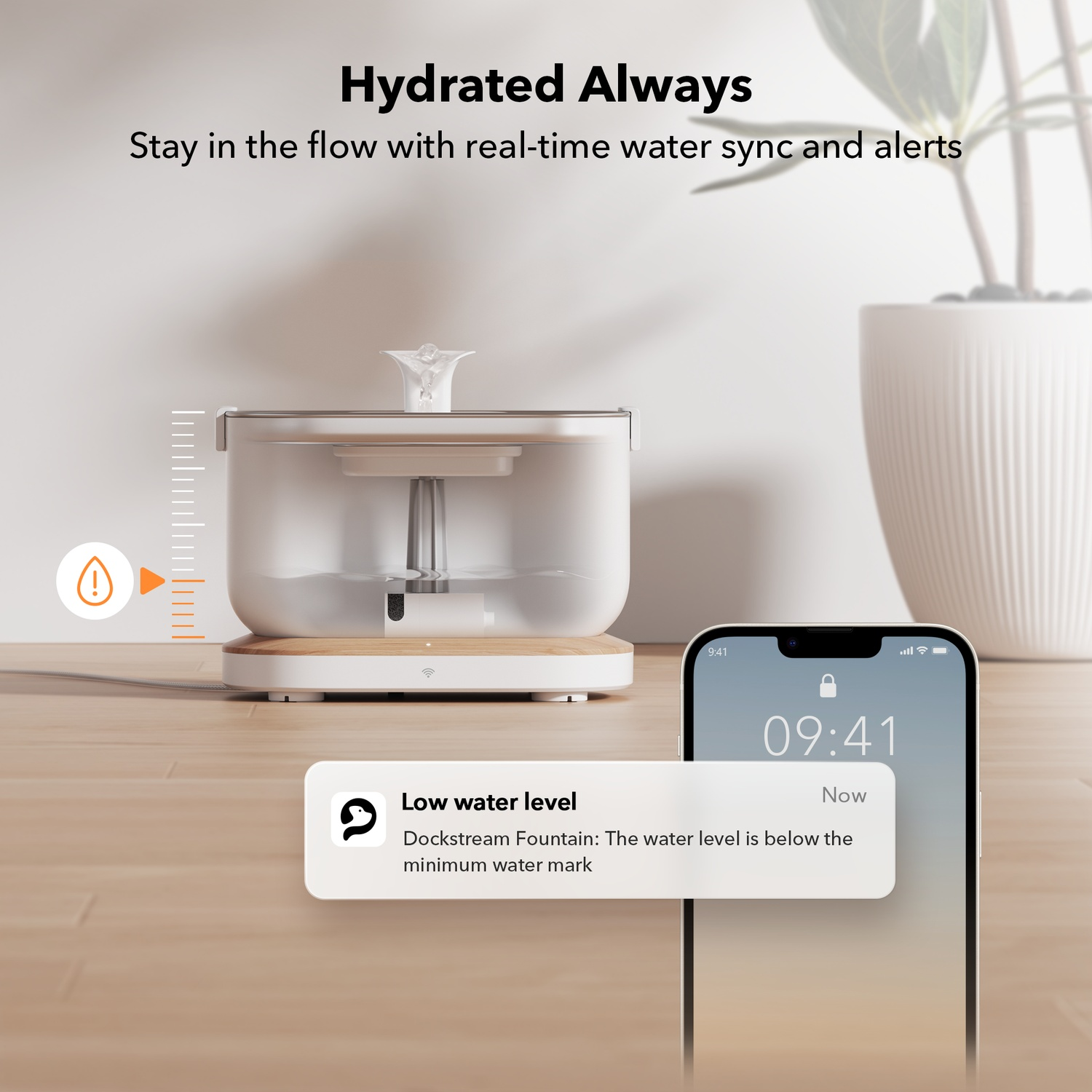 A white pet water fountain with a phone showing low water level. A plant is in the background.