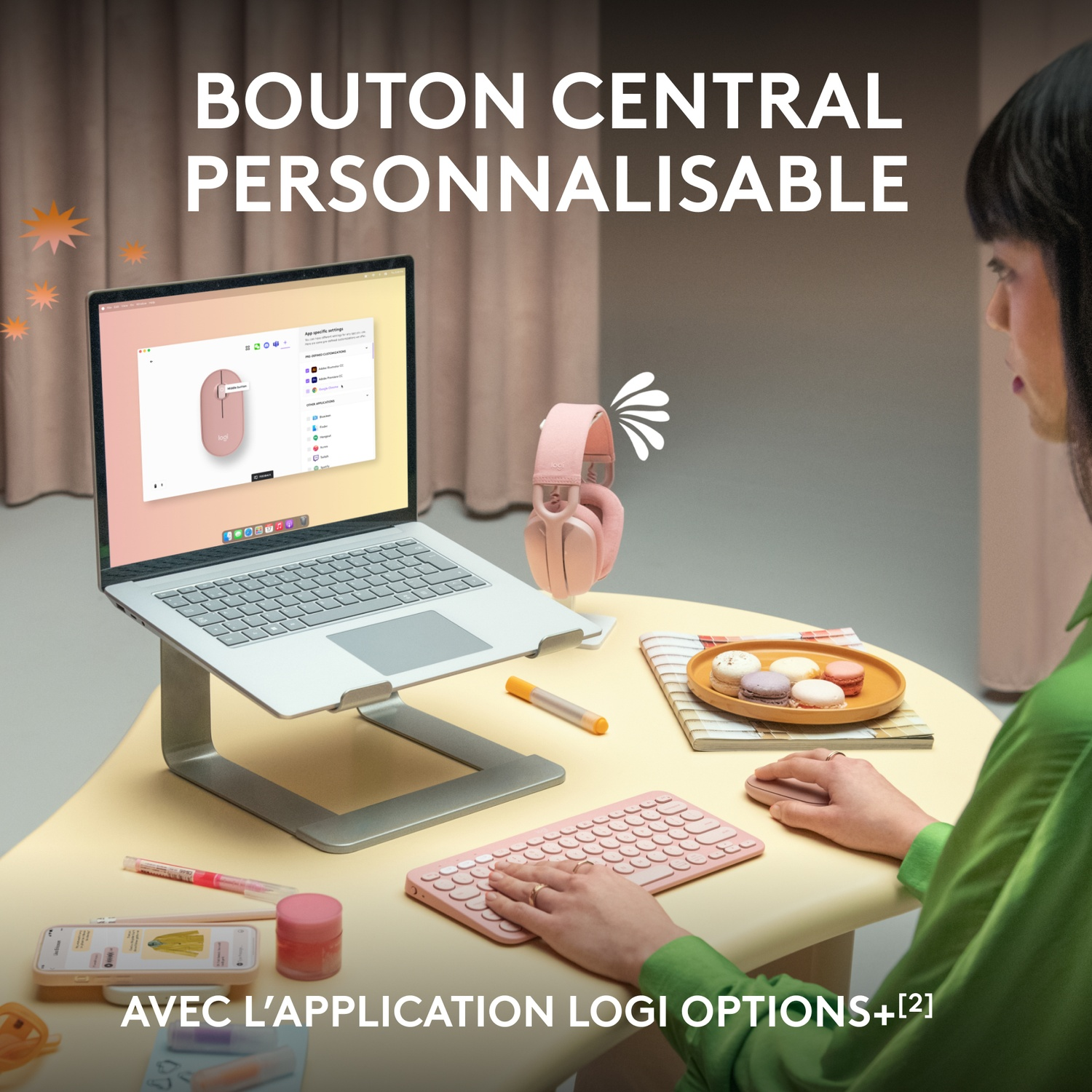 Personne travaillant sur un ordinateur portable avec accessoires. Casque rose, clavier, téléphone.