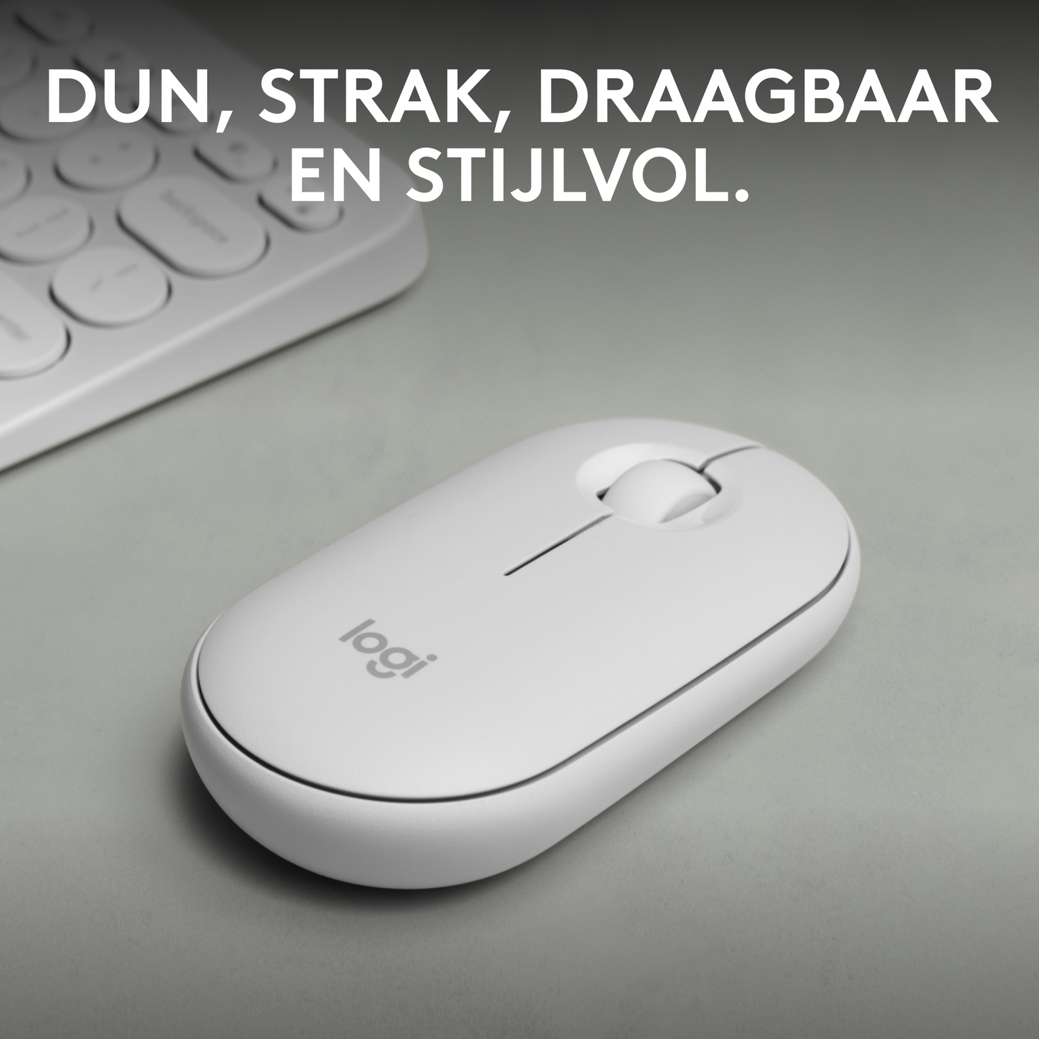 A white Logitech mouse next to a keyboard on a gray surface.
