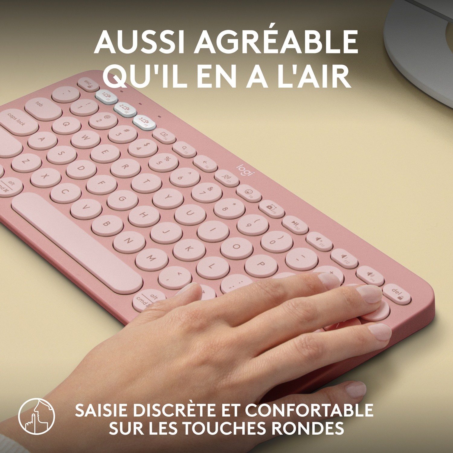 Une main utilisant un clavier rose avec des touches rondes, avec du texte sur le confort.