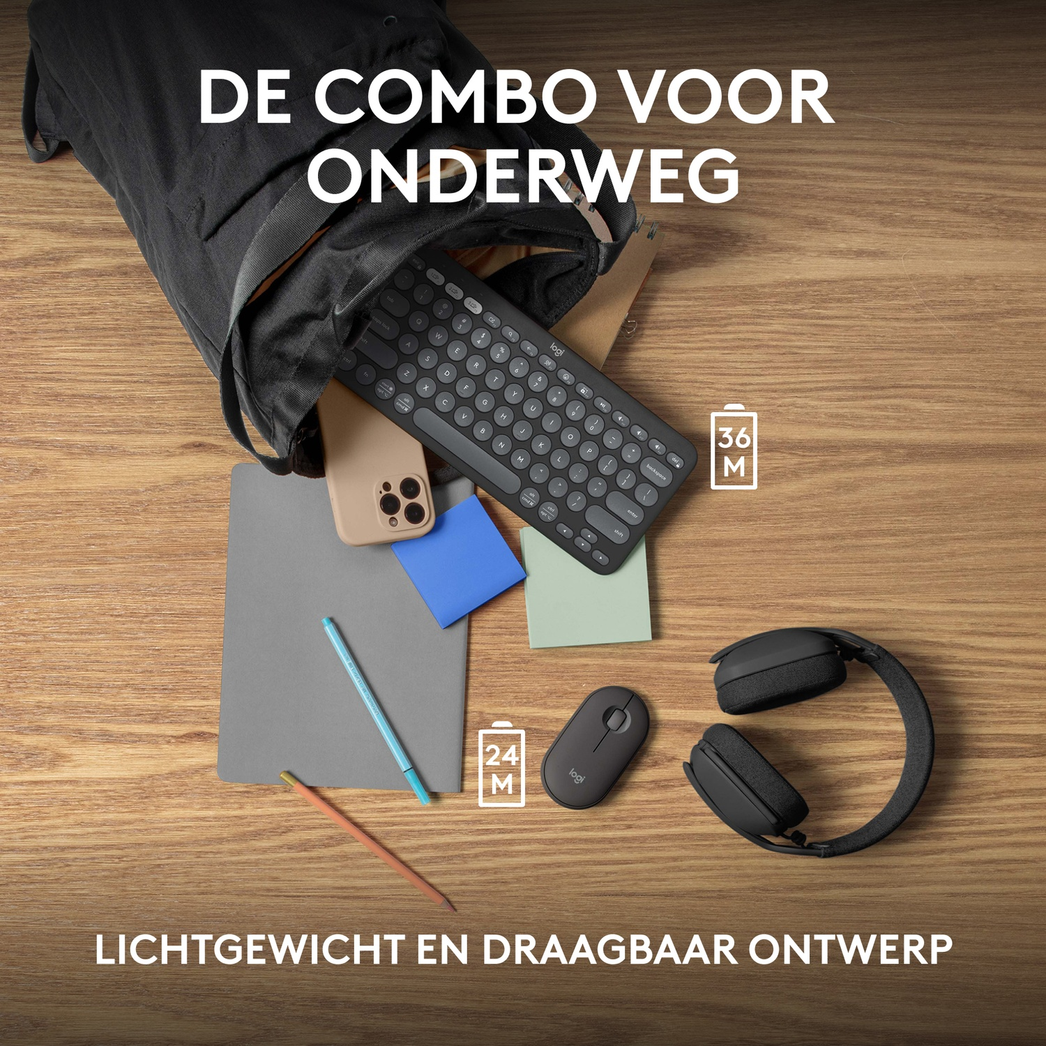 Black keyboard, mouse, phone, and accessories spilling from a black bag. Wooden table.