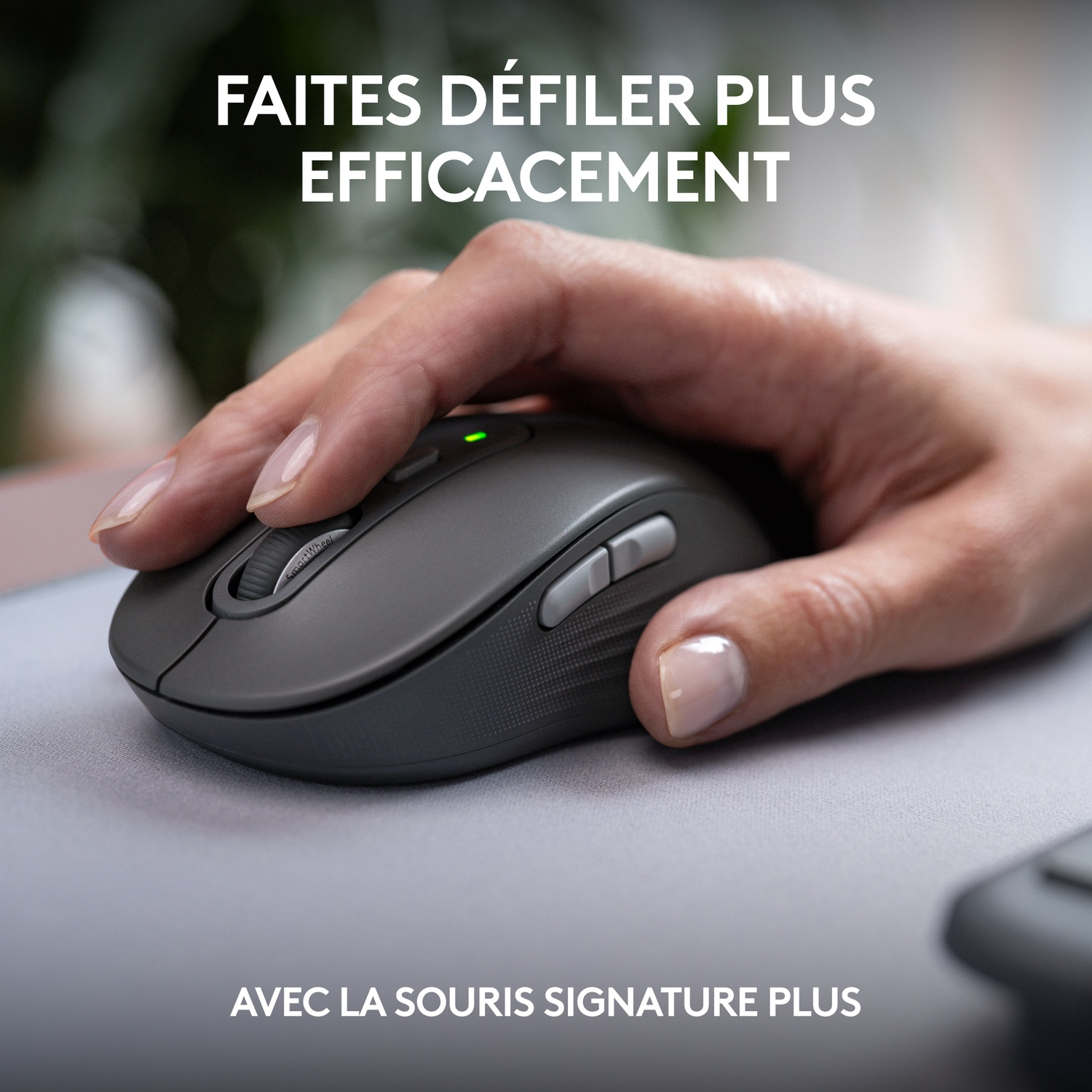 Main utilisant une souris grise. Tapis de souris gris clair. Souris Signature Plus. Gros plan, fond neutre.