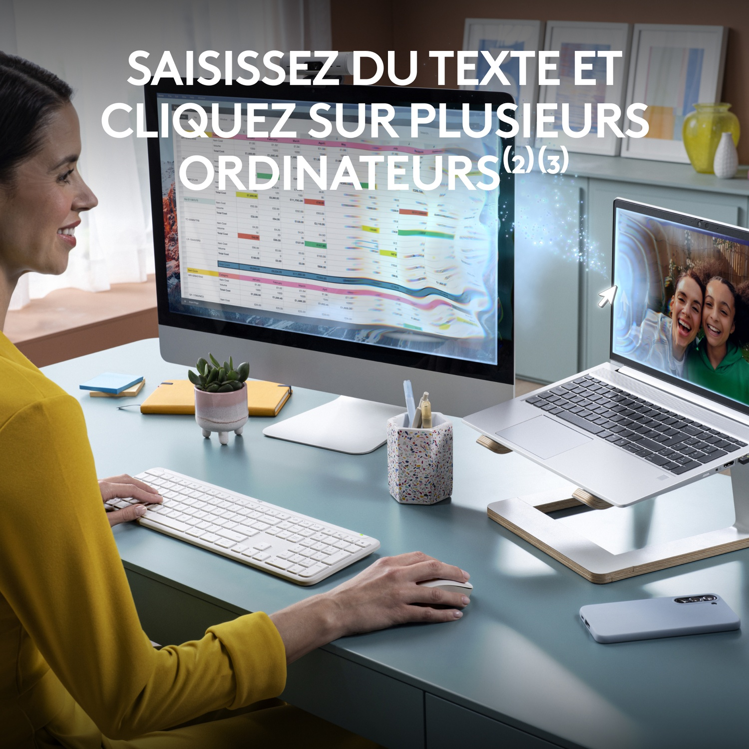 Femme utilisant une configuration informatique : moniteur, ordinateur portable, clavier et souris.