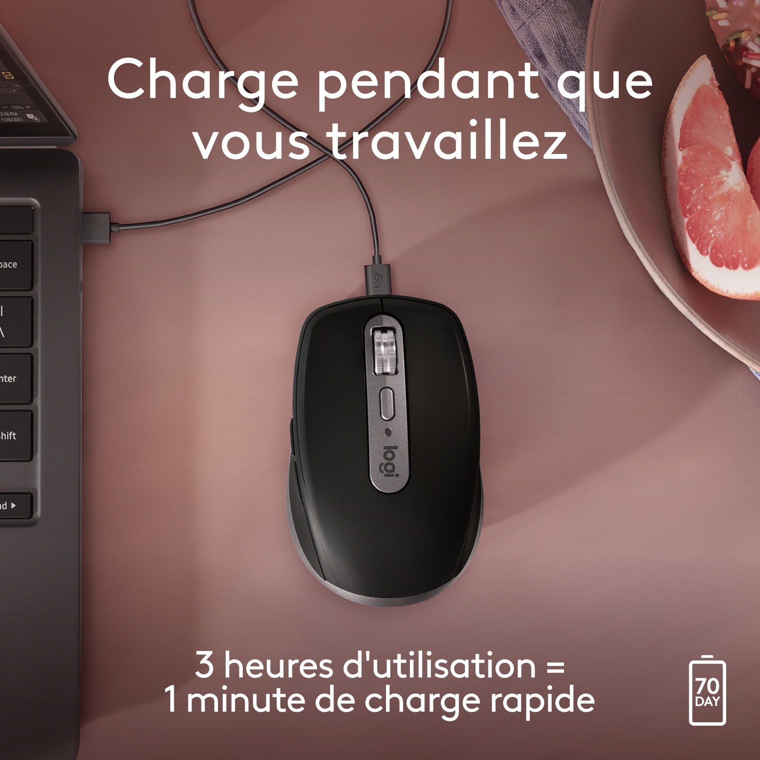 Une souris noire se chargeant avec un câble USB. La souris est sur une surface marron. Le texte dit : '3 heures d'utilisation = 1 min de charge'.