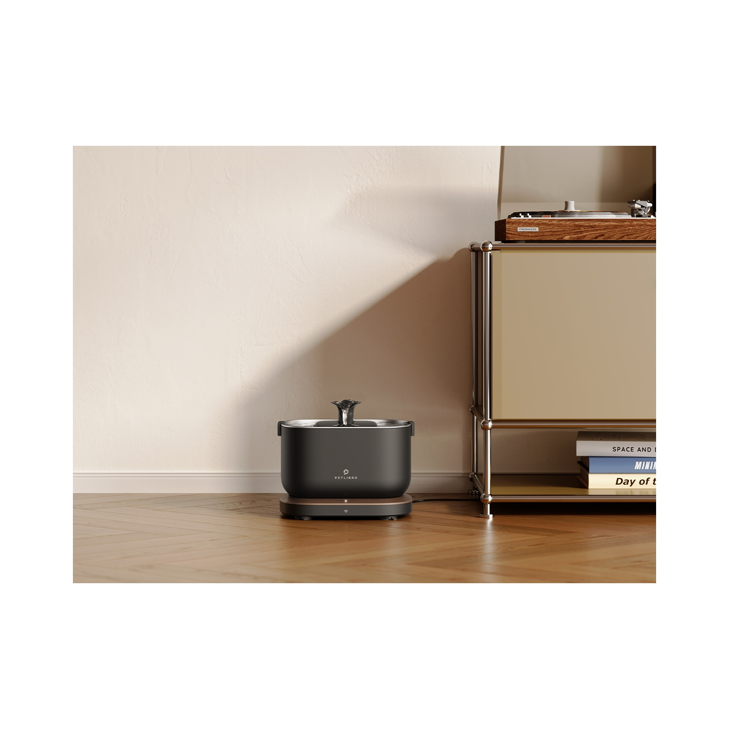 A black air purifier sits on a dark base. A neutral color wall in the background.