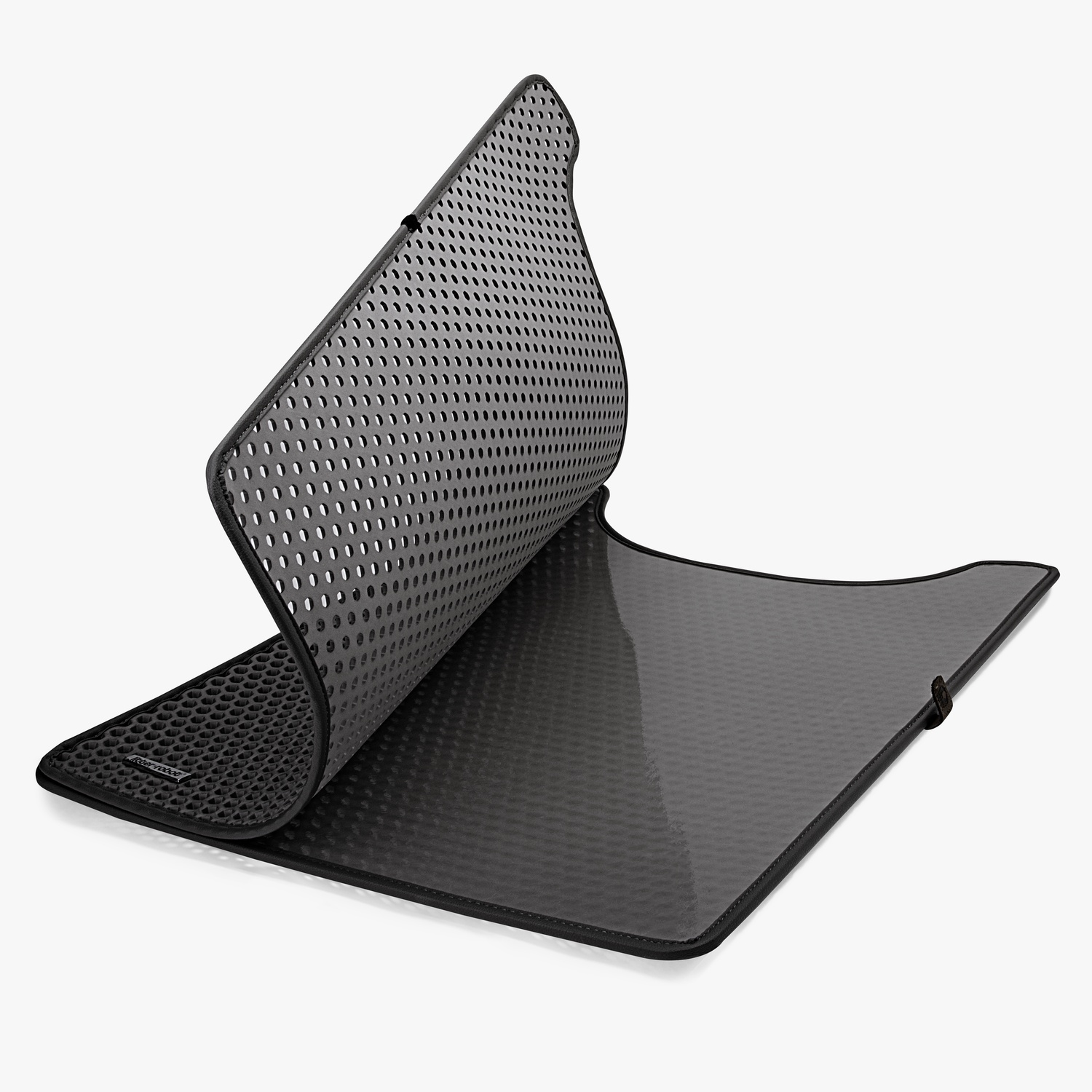 A black cat litter mat with a perforated top, partially folded, on a white background.