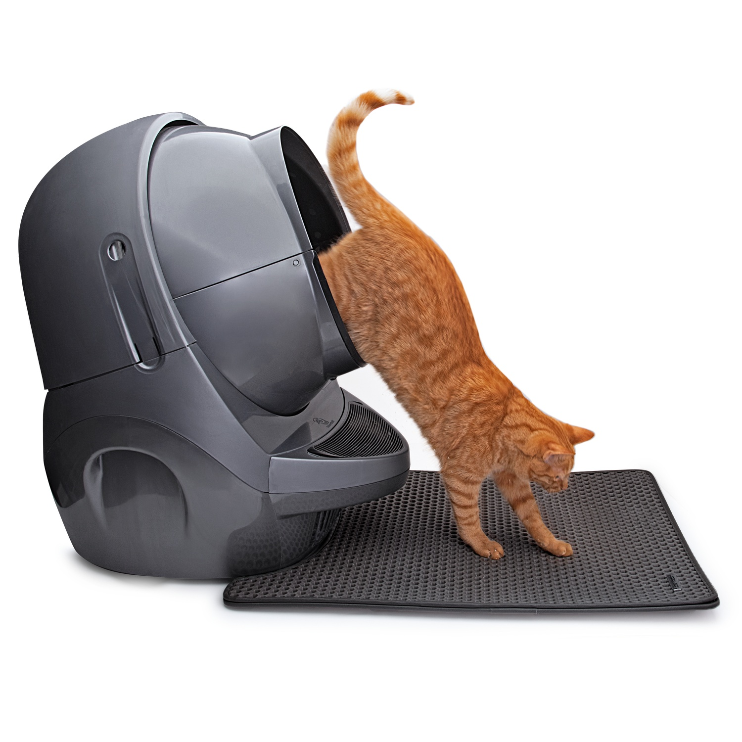 An orange cat exiting a grey automatic litter box. A black mat is beneath the box.