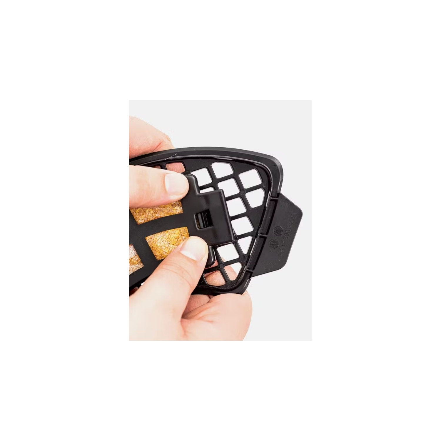 A person's hands are holding a black filter frame with a filter.