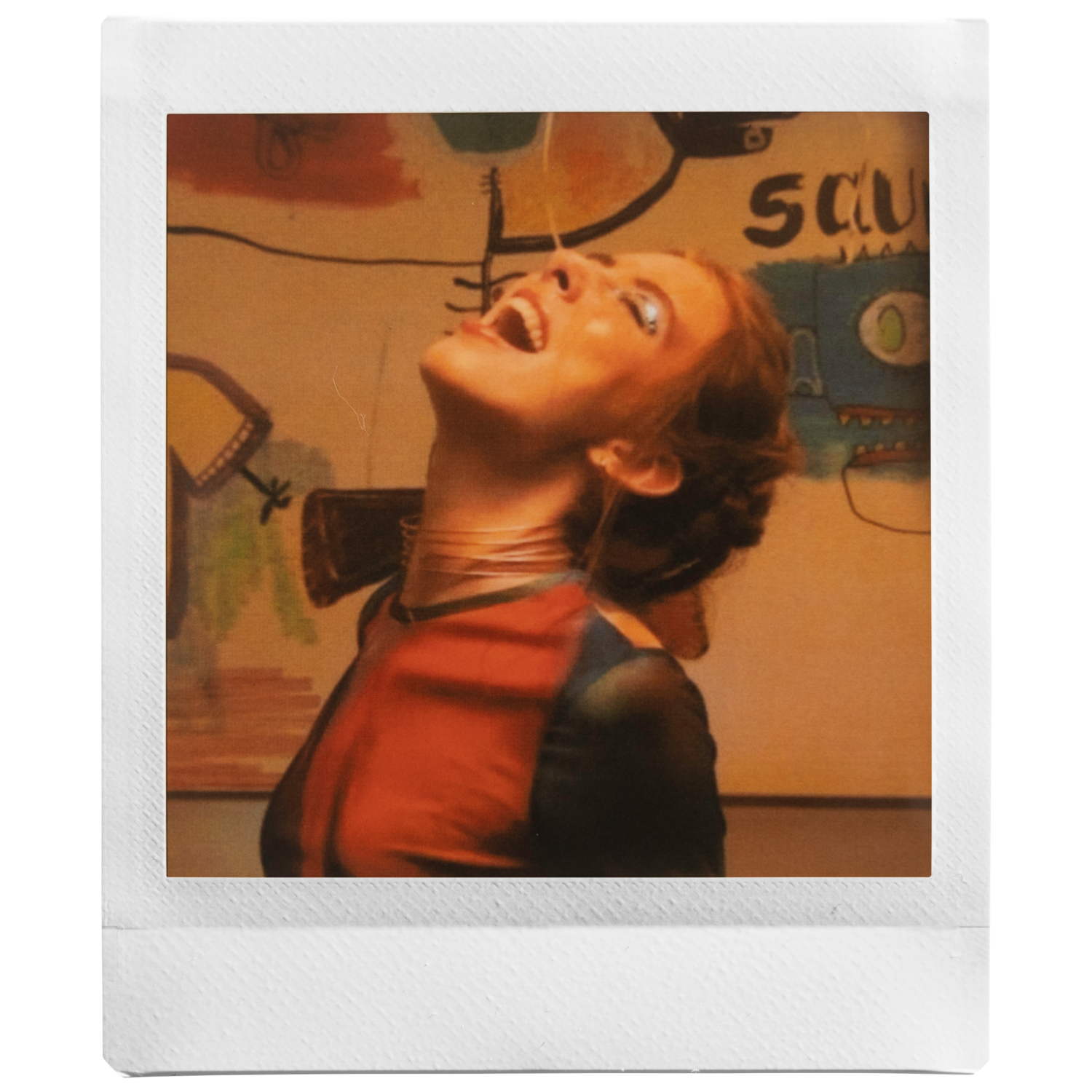 Une femme sur une photo polaroid qui rit et regarde en l'air.