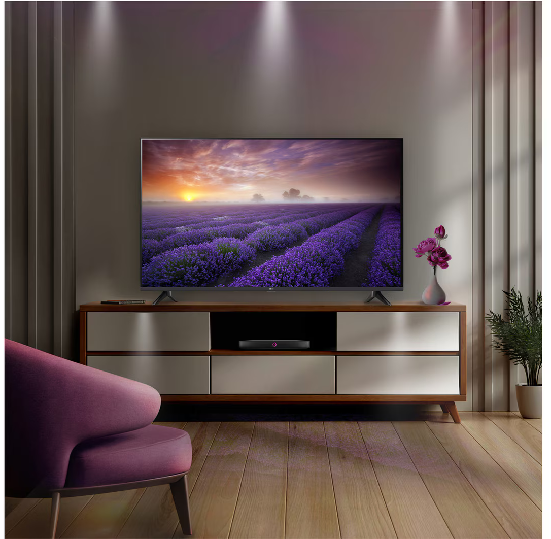 Nappali TV-vel, konzollal és lila székkel.