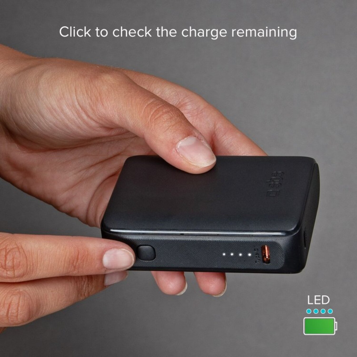 Main tenant une batterie externe noire avec des lumières LED indiquant la charge. Un bouton est à gauche.