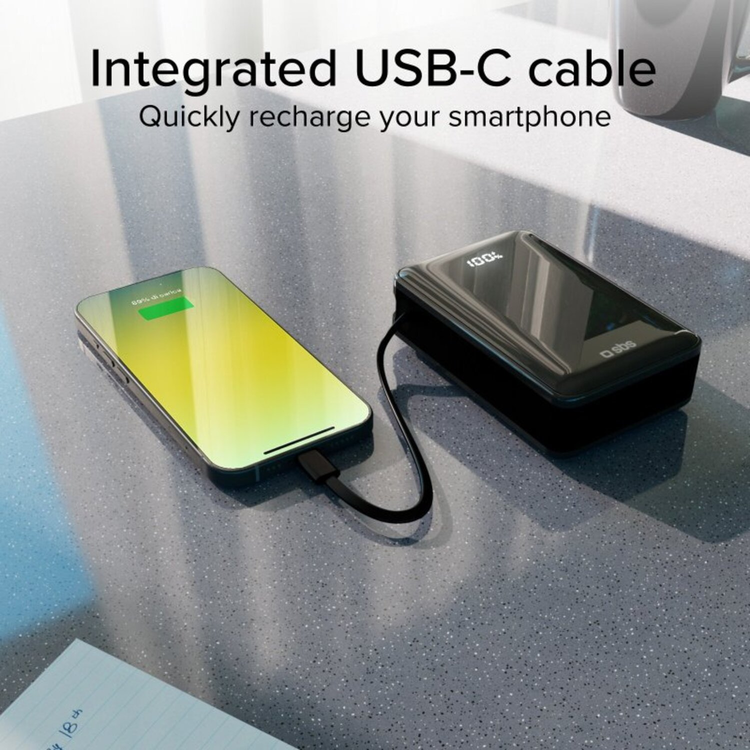 Un smartphone se chargeant via un câble USB-C connecté à une batterie externe noire.