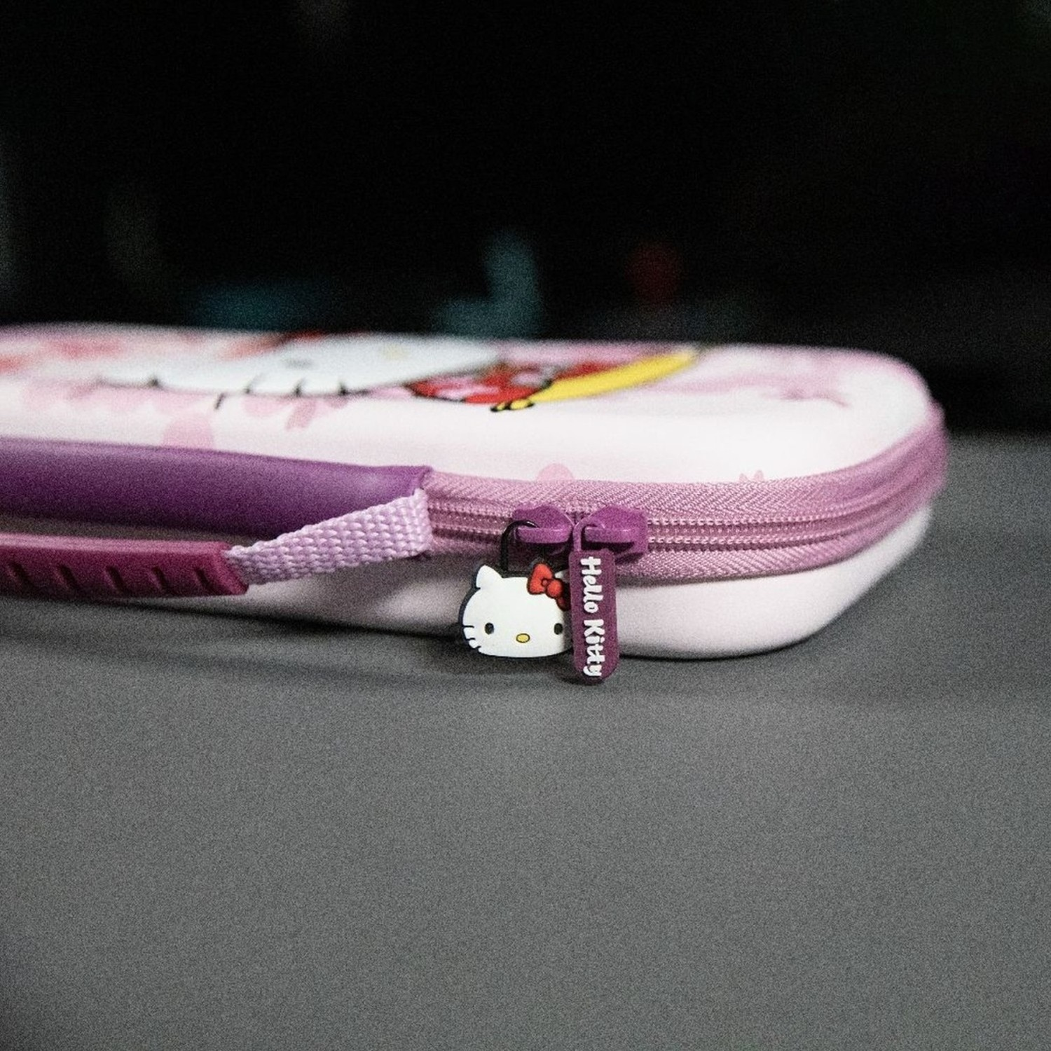 Une trousse Hello Kitty avec une fermeture éclair violette.