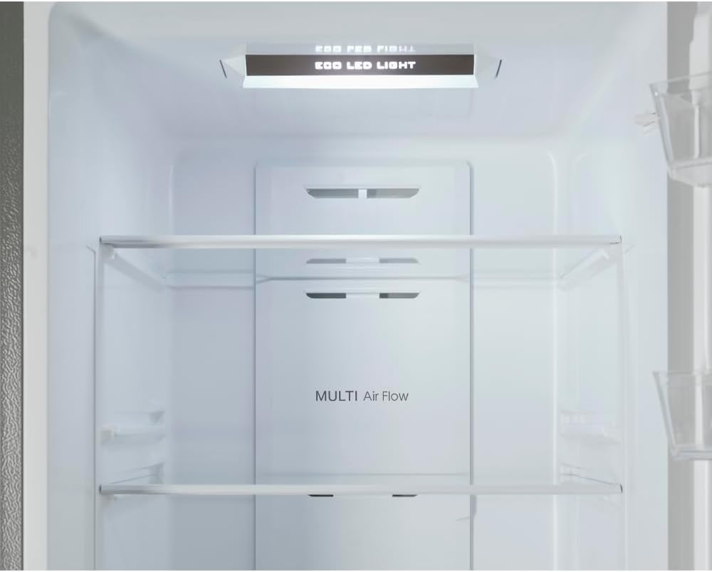 Dentro de un refrigerador. Hay estantes, una luz y un compartimento para el flujo de aire.