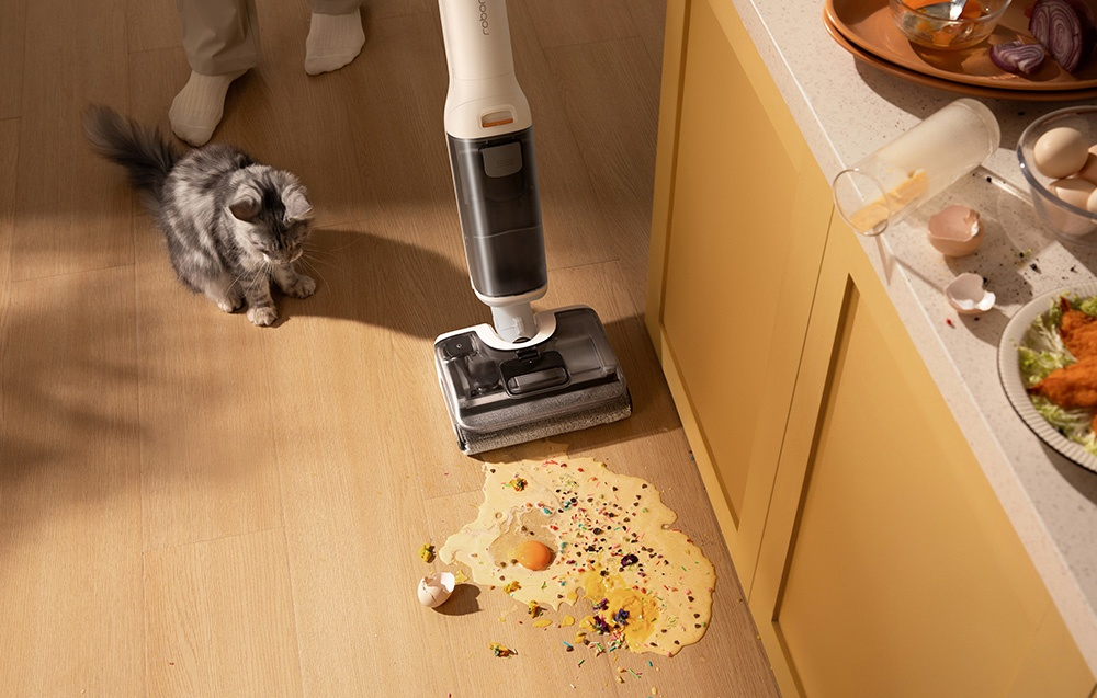 Rozlana masa jajeczna na drewnianej podłodze z maszyną czyszczącą.