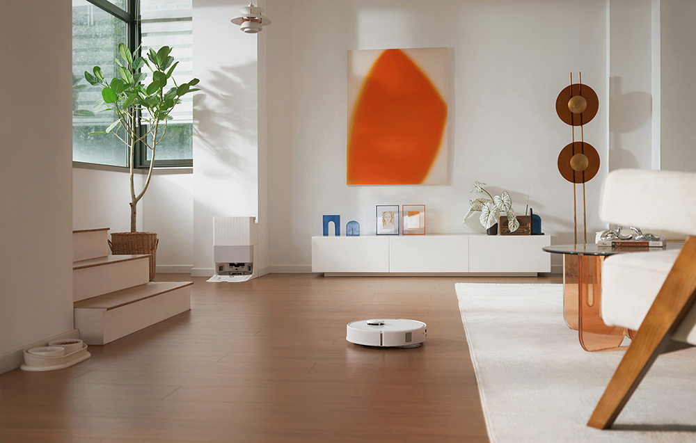 Nowoczesny salon z robotem sprzątającym. Pokój ma drewniane podłogi, dywan i sztukę.