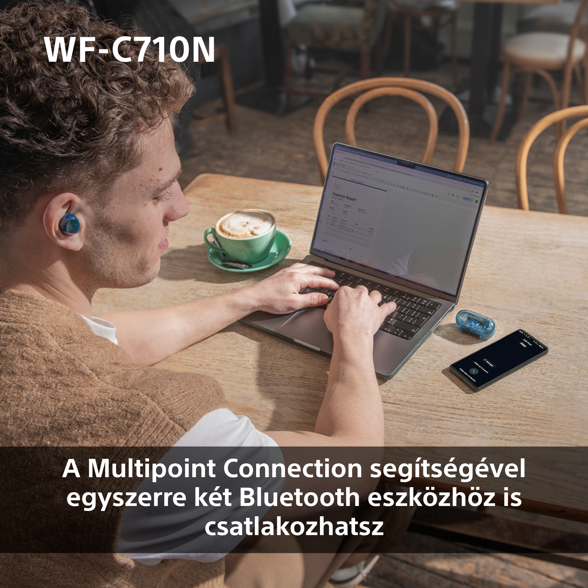 Egy személy laptopot használ fülhallgatóval és okostelefonnal az asztalon.