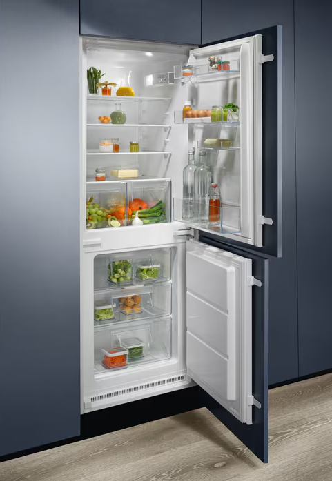 Geöffneter Kühlschrank, gefüllt mit Lebensmitteln. Regale mit Obst, Gemüse und Gläsern.