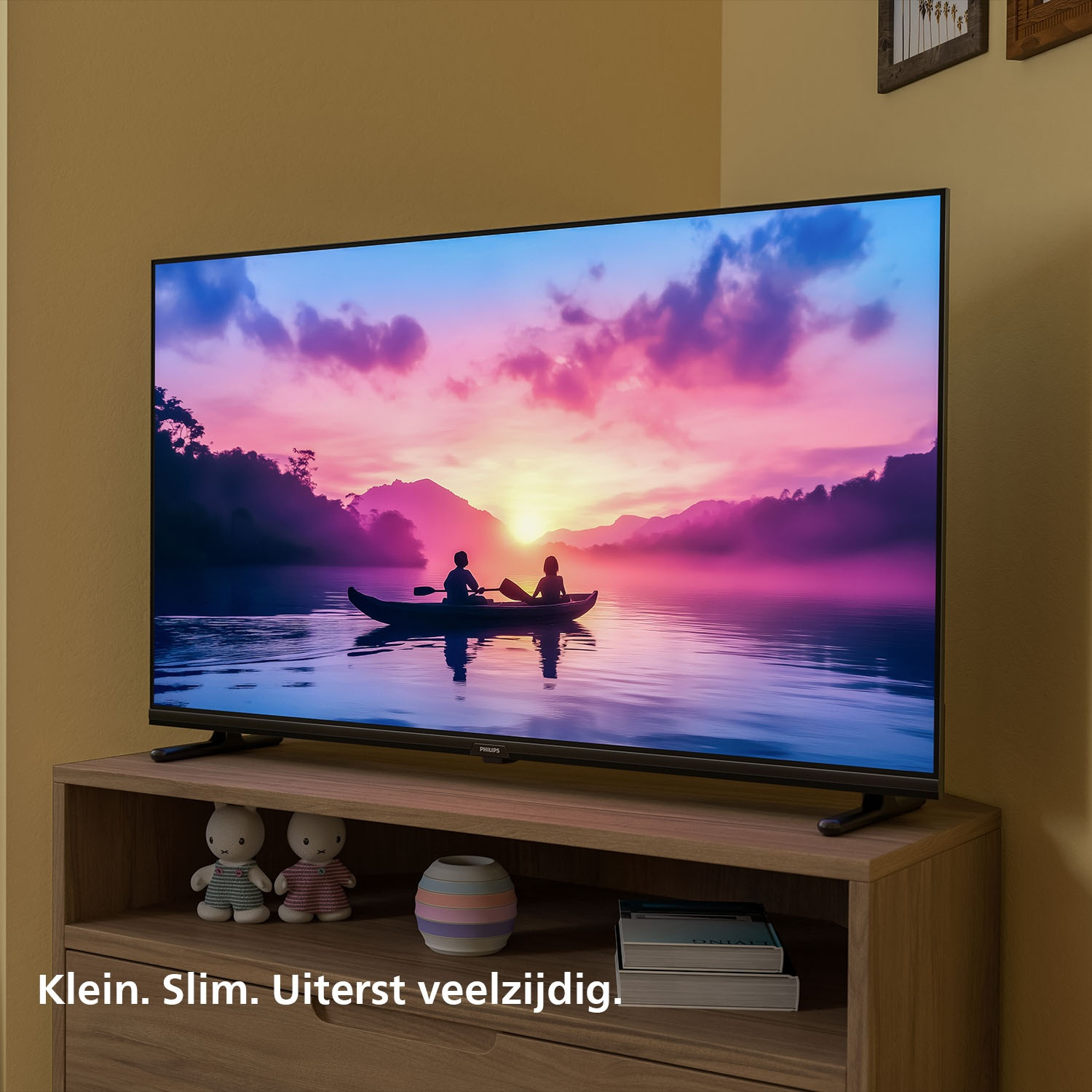 TV op een standaard met een zonsondergang boven water. Een boot is te zien.