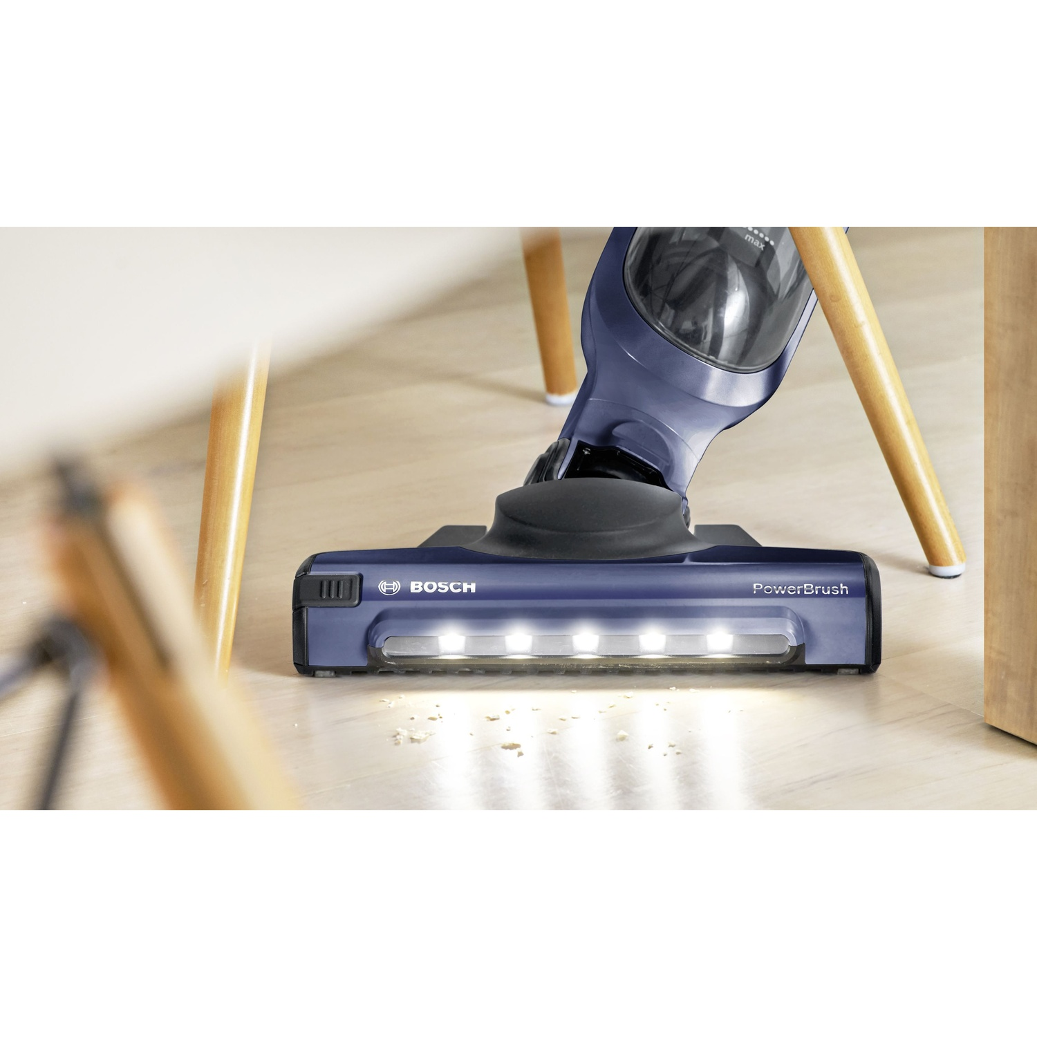 Aspirapolvere cordless blu su pavimento in legno. Testina visibile. Logo Bosch.