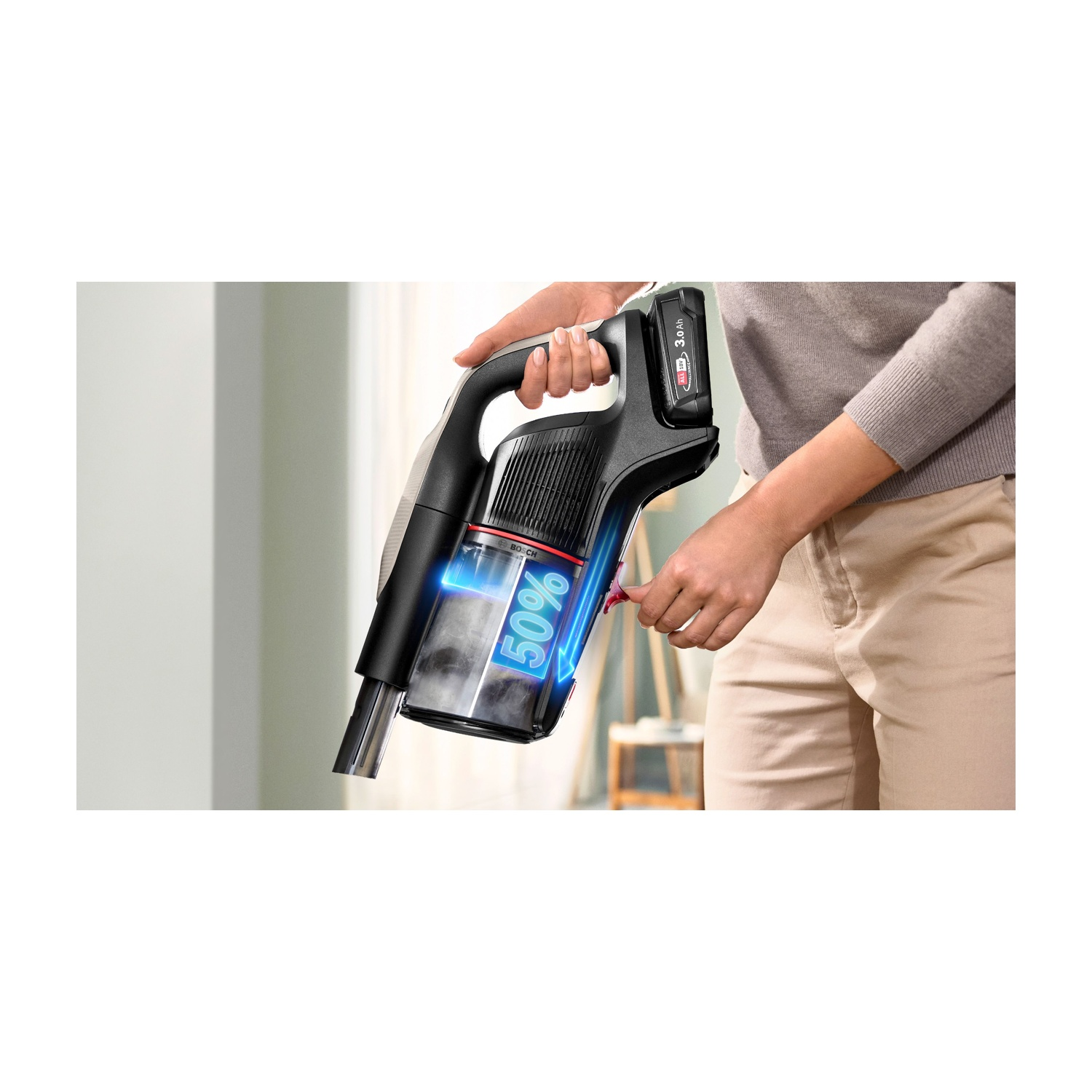 Donna che tiene un aspirapolvere senza fili. Il display mostra 50% batteria.