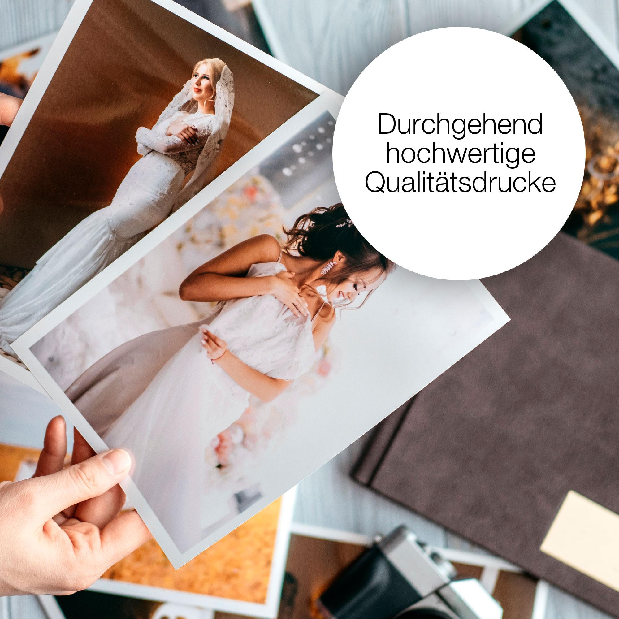 Eine Person hält Fotos einer Braut in einem weißen Kleid. Fotos liegen auf einem Tisch.