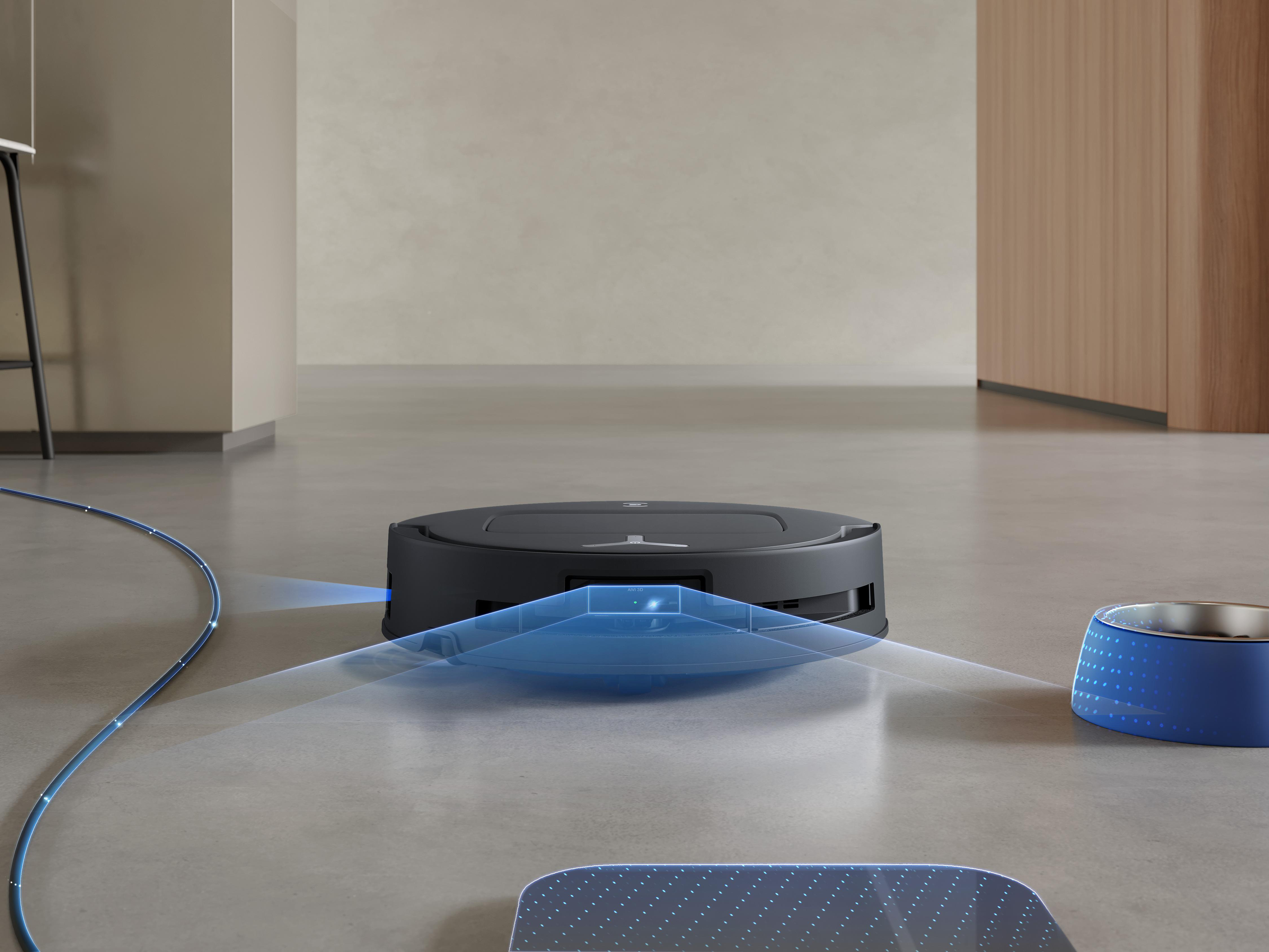 Ein schwarzer Roboter-Staubsauger auf einem Boden mit blauem Lichtpfad und einer blauen Futterschüssel.
