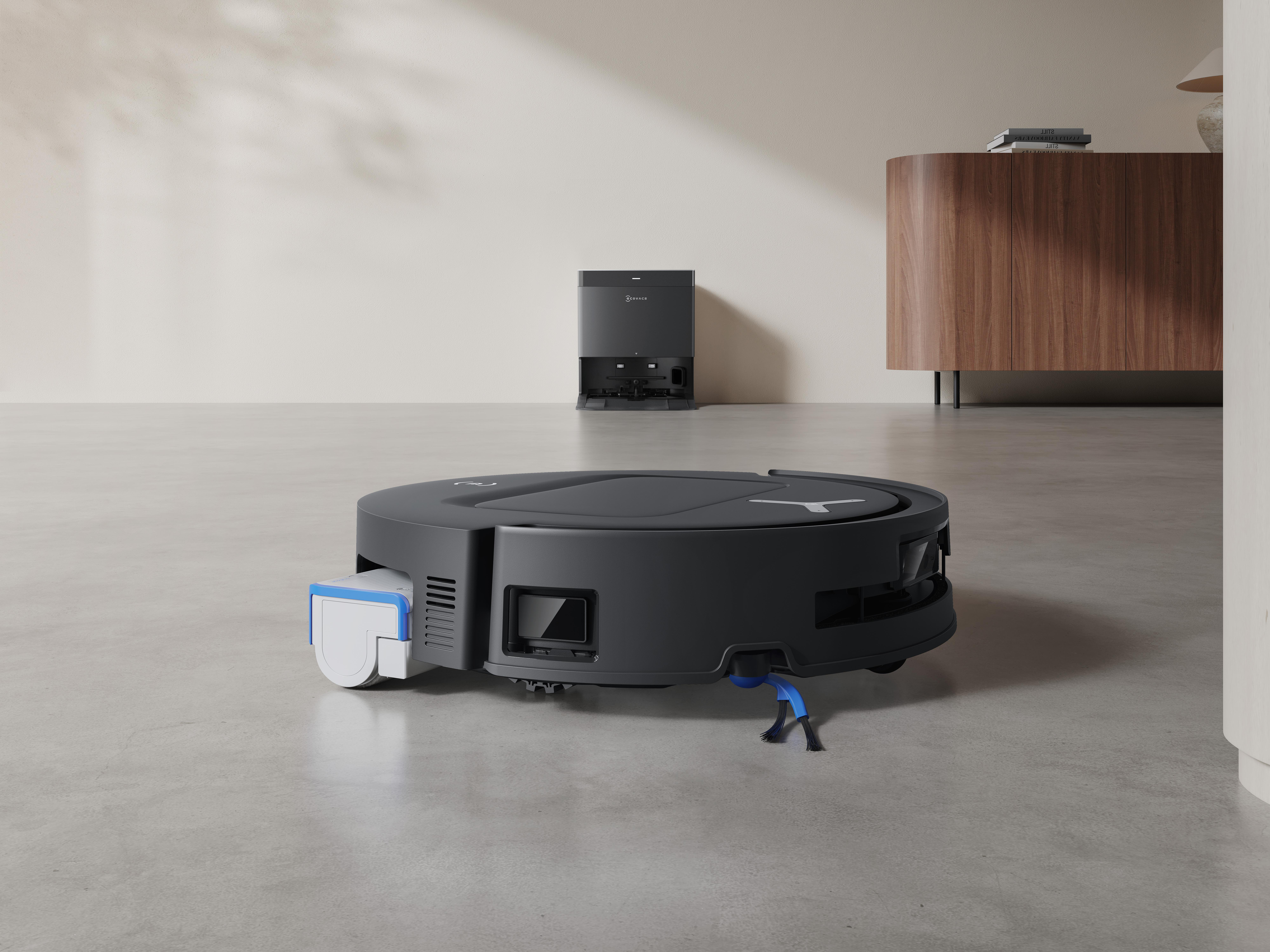 Ein schwarzer Roboter-Staubsauger mit einer Ladestation in einem modernen Raum.