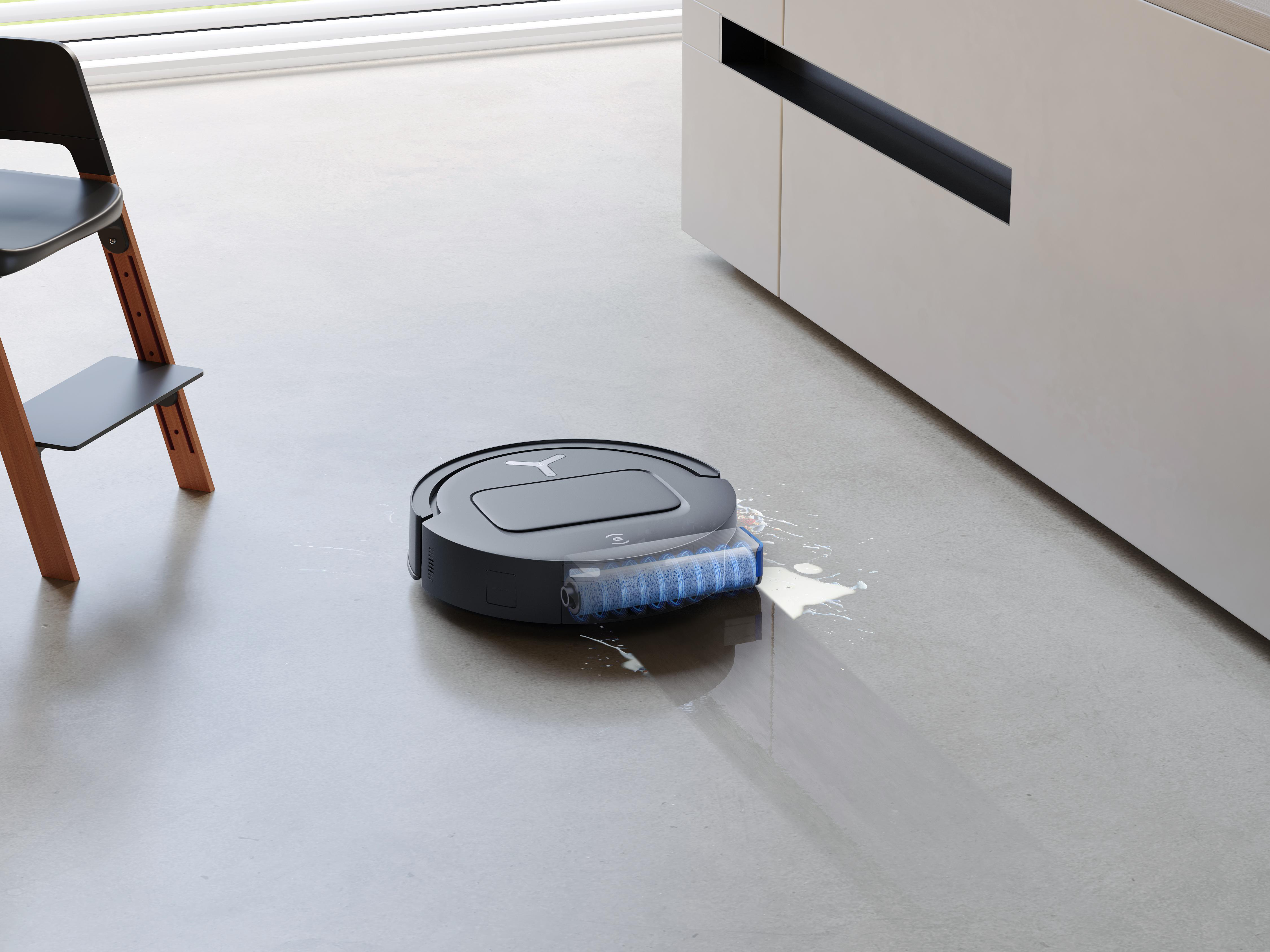 Roboter-Staubsauger reinigt Boden mit verschütteter Flüssigkeit. Stuhl und Schrank sichtbar.