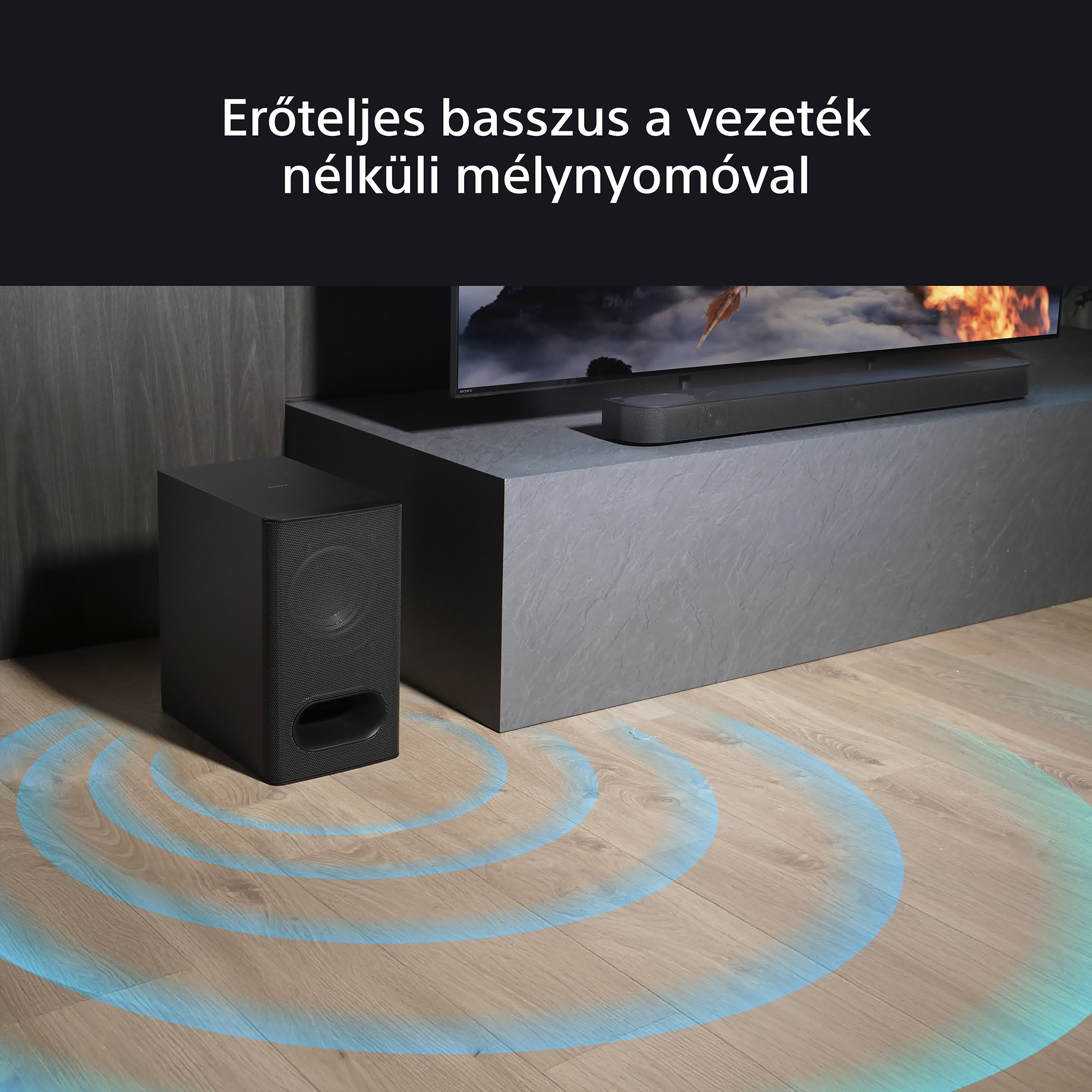 Egy fekete mélynyomó és soundbar felállás. Kék hanghullámok terjednek a mélynyomóból.