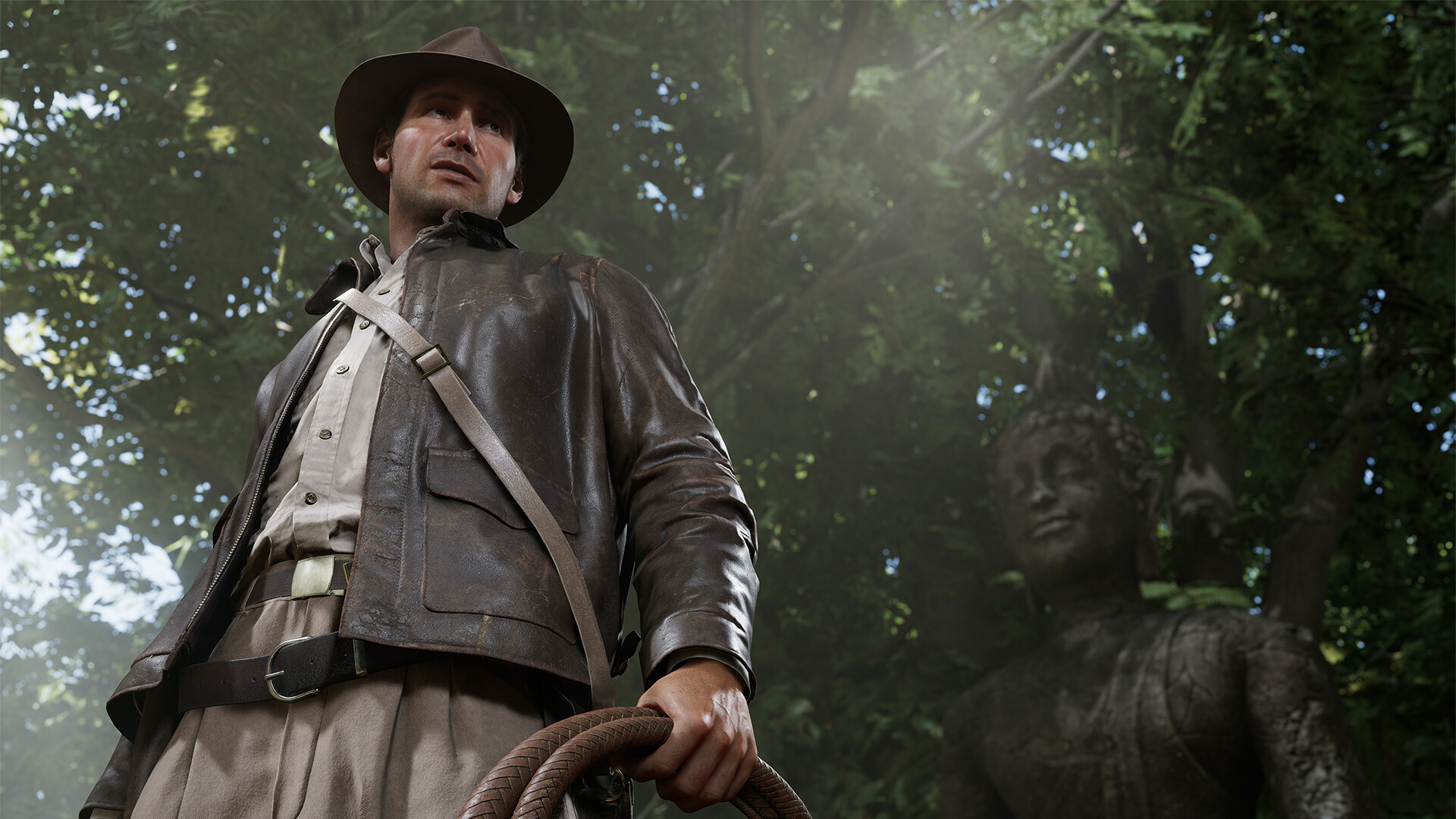 Indiana Jones con una frusta, in una giungla con una statua sullo sfondo.