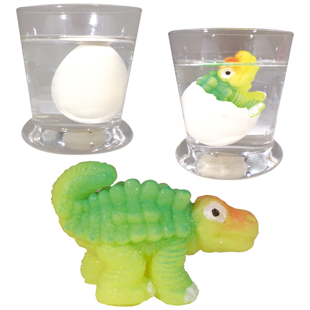 Huevos, uno entero y otro eclosionando, con un juguete de dinosaurio verde.
