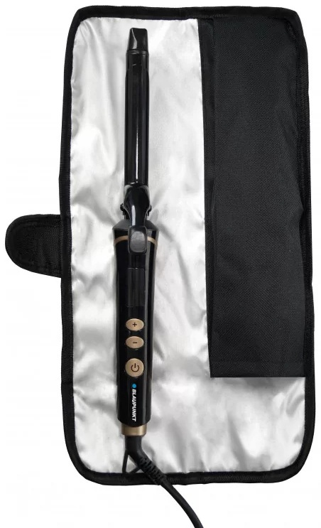 Osoba trzyma broszurę na drewnianym stole.