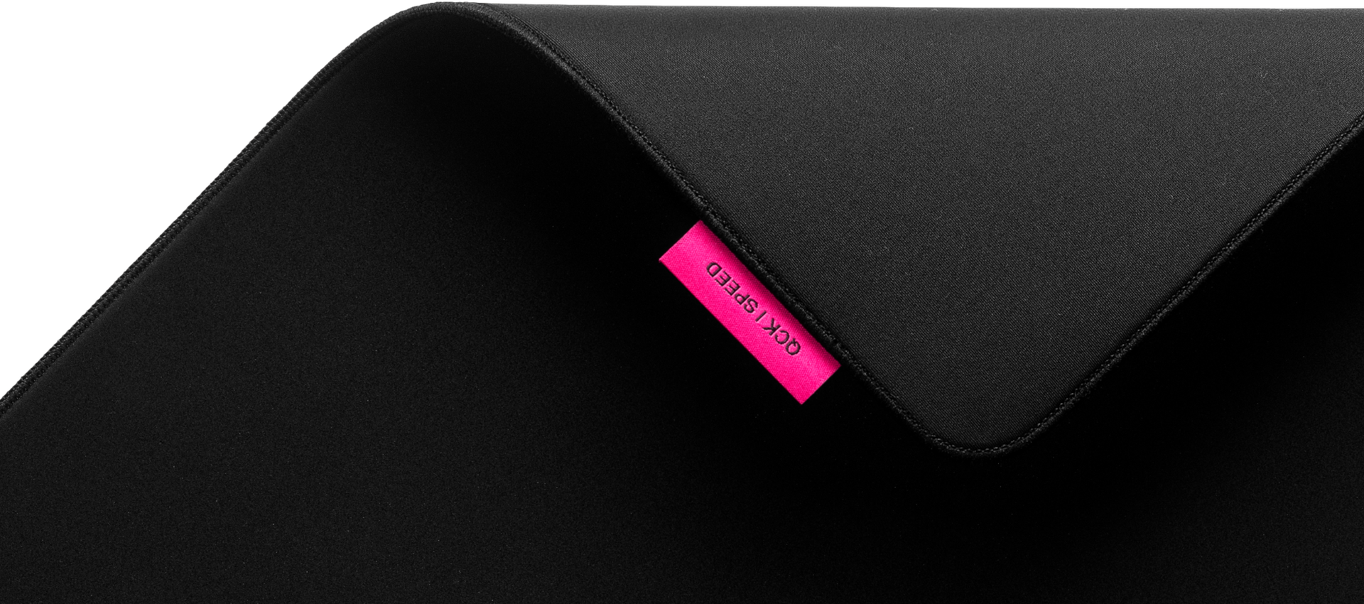 Un tapis de souris noir avec une étiquette rose qui dit 'Gck / Speed'.
