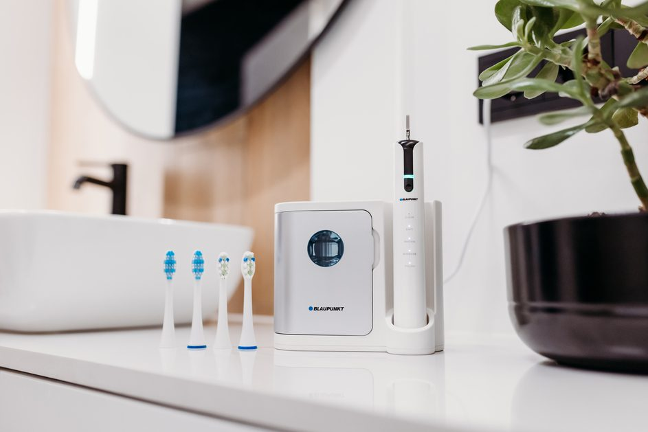 Łazienka ze szczoteczką do zębów, elektryczną szczoteczką do zębów i rośliną.