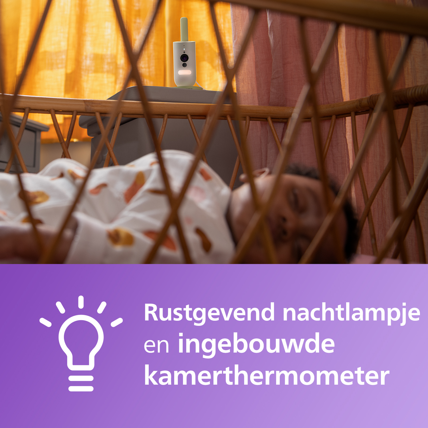 Babyfoon in een wieg met een slapende baby. Achtergrond: raam en gordijnen.