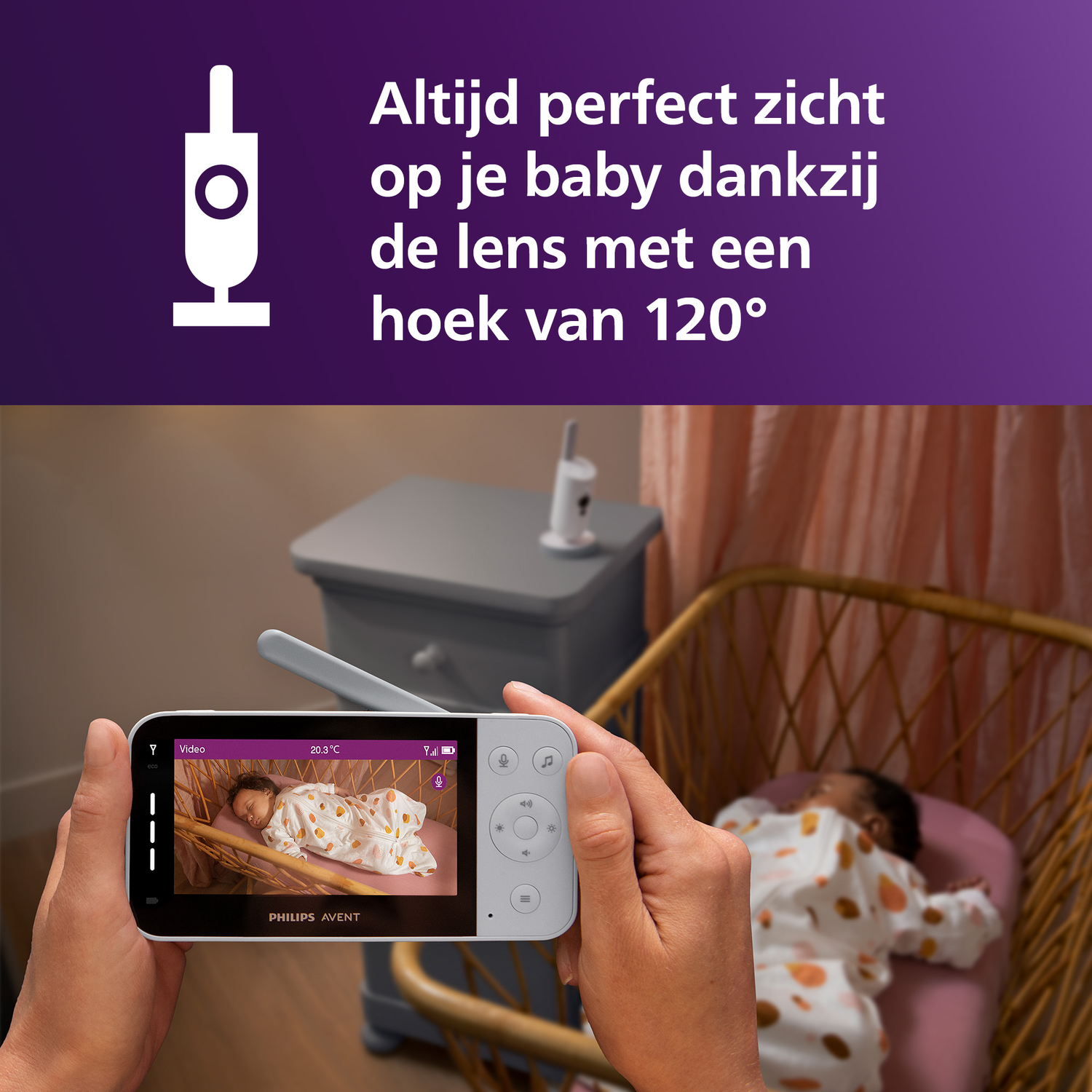 Een persoon houdt een babyfoon vast met een slapende baby in een wieg.