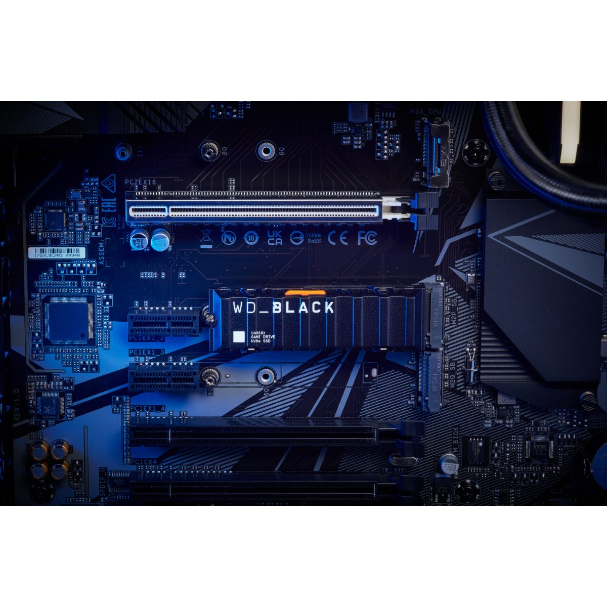 Una placa base de computadora con una SSD. La placa base es azul oscuro y la SSD es negra.
