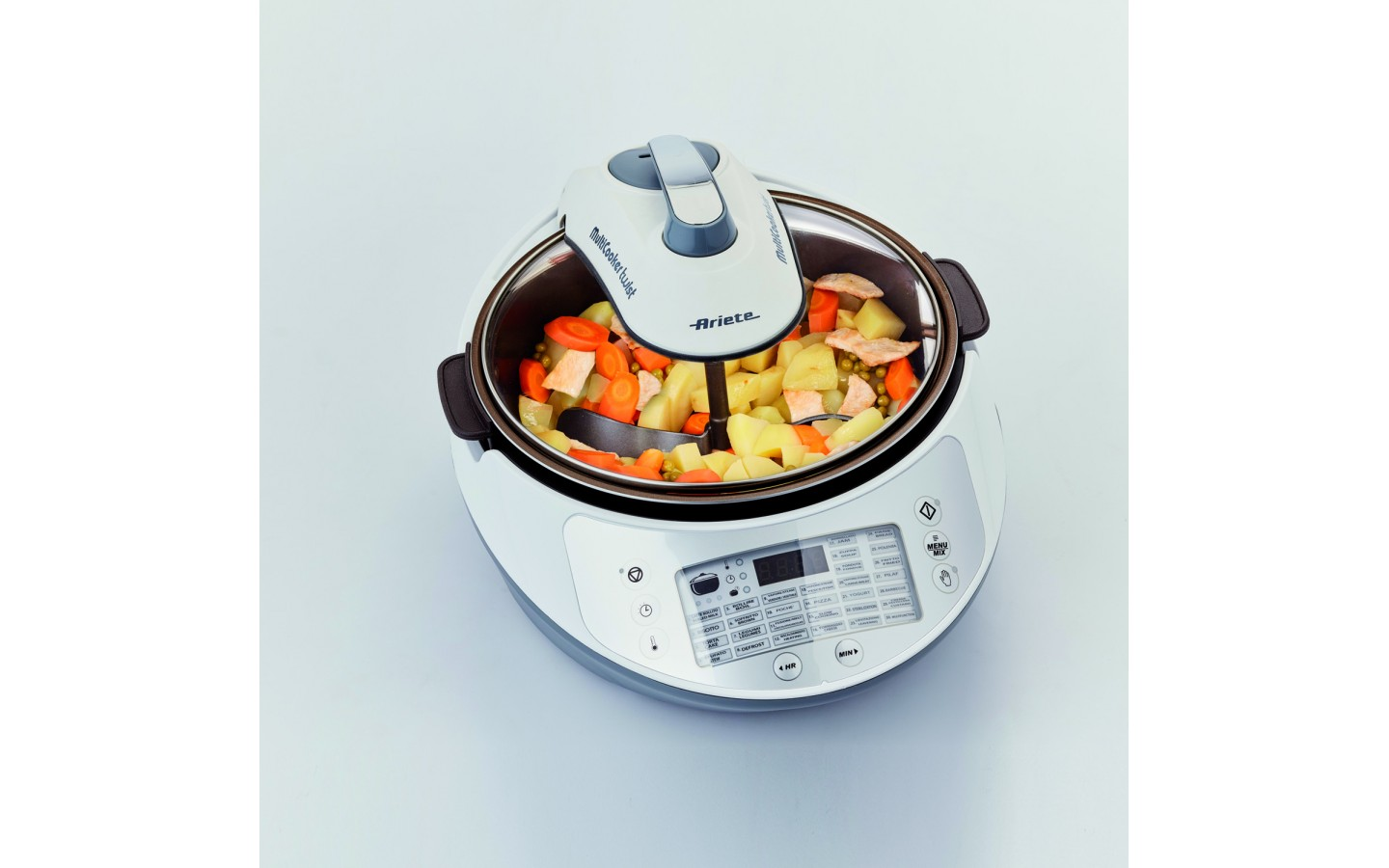 Biało-szara wielofunkcyjna kuchenka Ariete, z warzywami w środku na białej powierzchni.