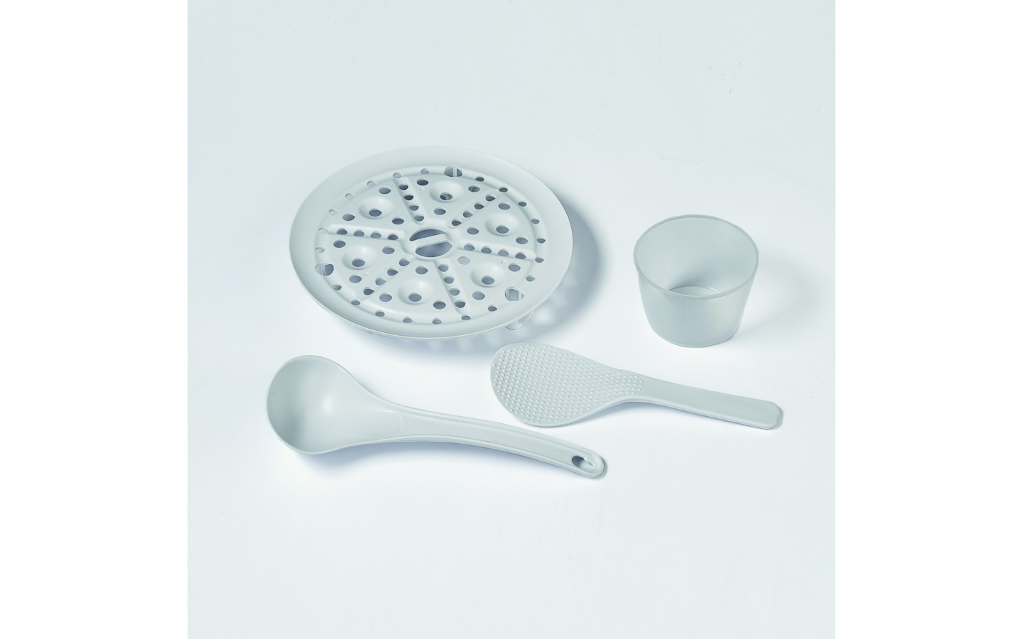 Szare akcesoria do ryżowaru: miska, chochla i dwa przybory na białym tle.