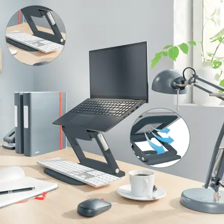 Egy laptop állványon billentyűzettel és egérrel. További részletek körökben.